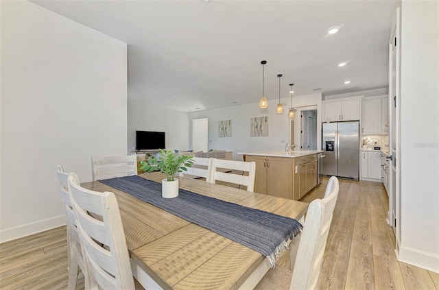 dining space with recessed lighting, light wood-style flooring, and baseboards