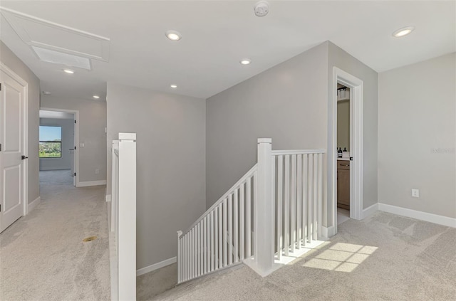 corridor with recessed lighting, baseboards, light colored carpet, and an upstairs landing