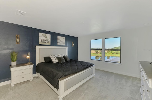 bedroom featuring baseboards, visible vents, and light colored carpet