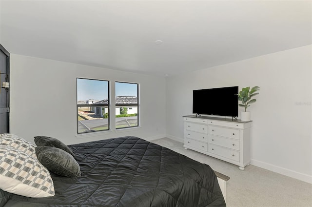 bedroom with baseboards and light colored carpet