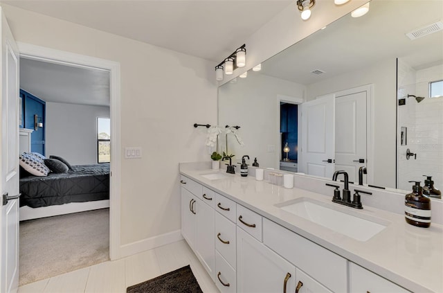 ensuite bathroom featuring a tile shower, ensuite bath, a sink, and visible vents