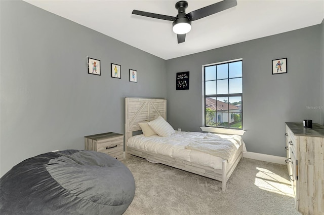 bedroom with light carpet, a ceiling fan, and baseboards