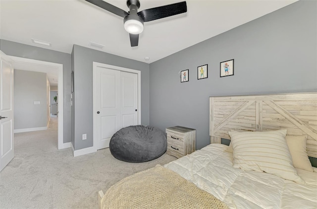 bedroom featuring a closet, visible vents, a ceiling fan, light carpet, and baseboards