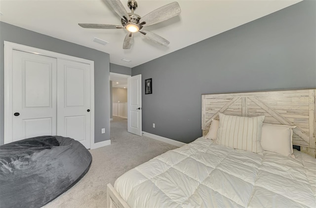 bedroom featuring a closet, visible vents, a ceiling fan, light carpet, and baseboards