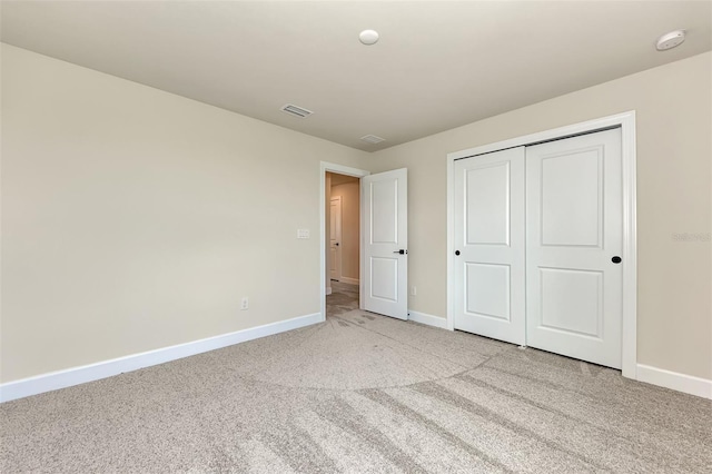 unfurnished bedroom with a closet, light carpet, visible vents, and baseboards