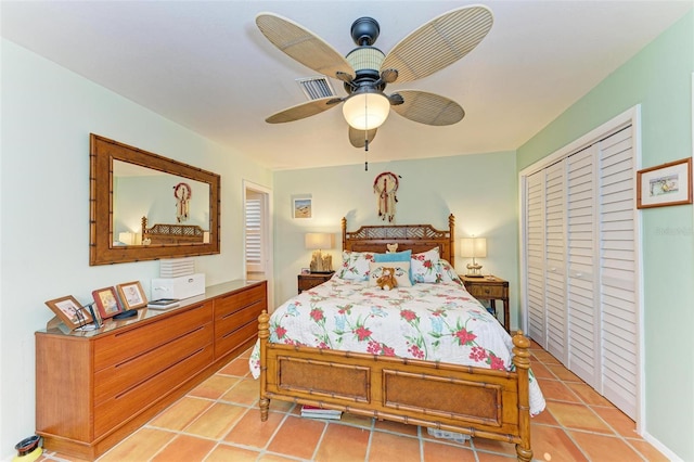 bedroom with ceiling fan, light tile patterned floors, and a closet