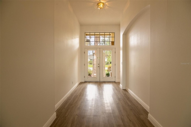 doorway featuring dark hardwood / wood-style floors, a towering ceiling, and french doors