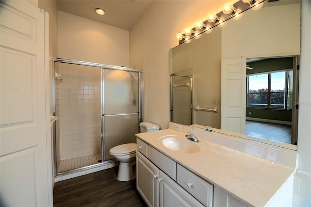 bathroom featuring hardwood / wood-style floors, vanity, toilet, and an enclosed shower