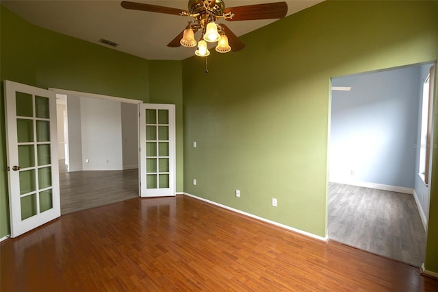 empty room featuring ceiling fan, french doors, and wood-type flooring