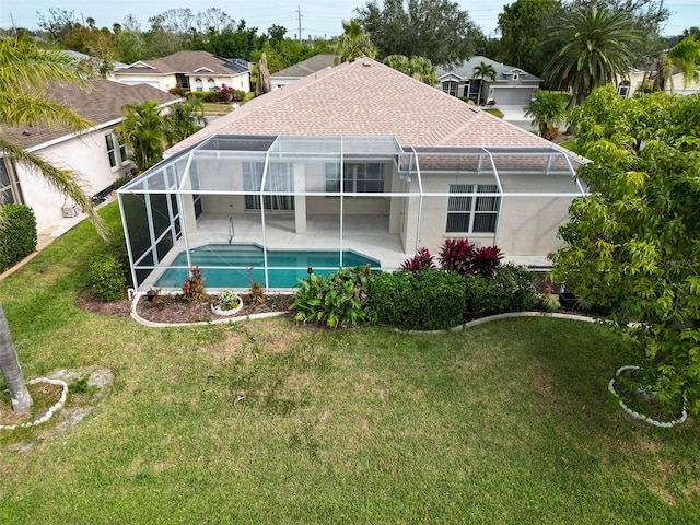 rear view of house with a lanai, a patio area, and a lawn