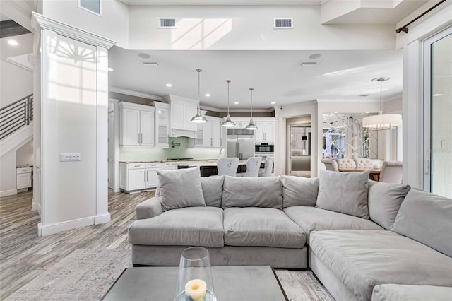 living room featuring light hardwood / wood-style floors and ornamental molding