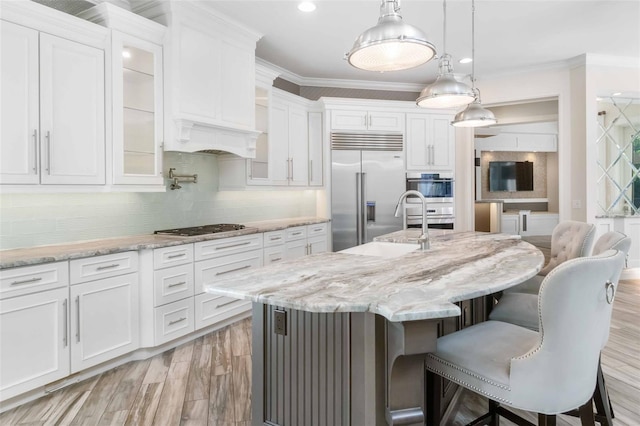 kitchen featuring a center island with sink, white cabinets, and stainless steel appliances