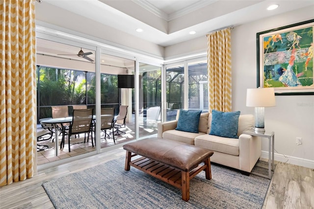 living room with ceiling fan, wood-type flooring, and crown molding