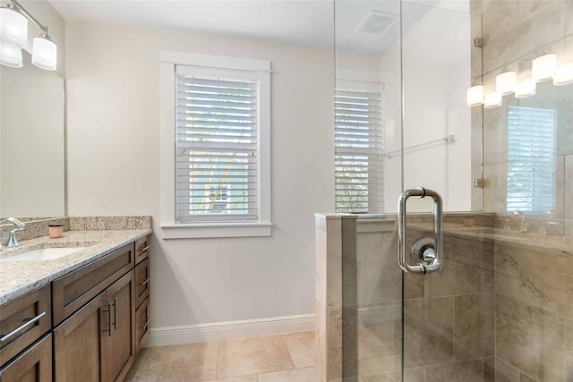 bathroom with tile patterned flooring, vanity, and a shower with door