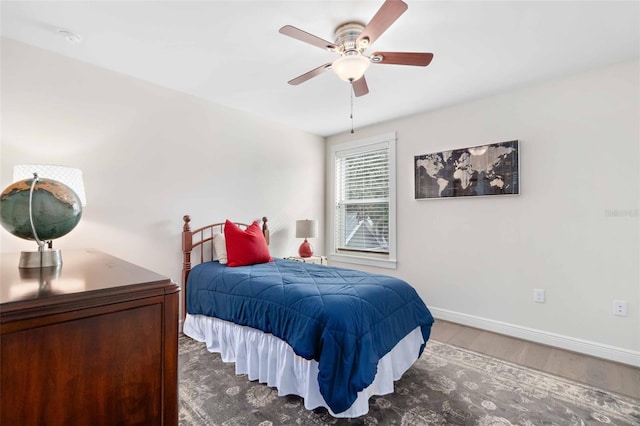 bedroom with dark hardwood / wood-style flooring and ceiling fan