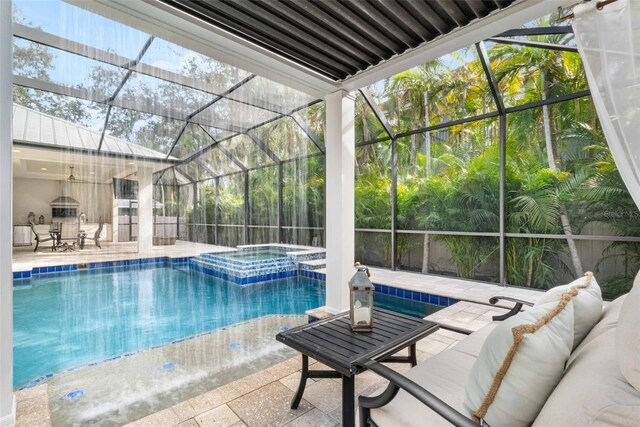 view of pool with an in ground hot tub, outdoor lounge area, a patio, and glass enclosure