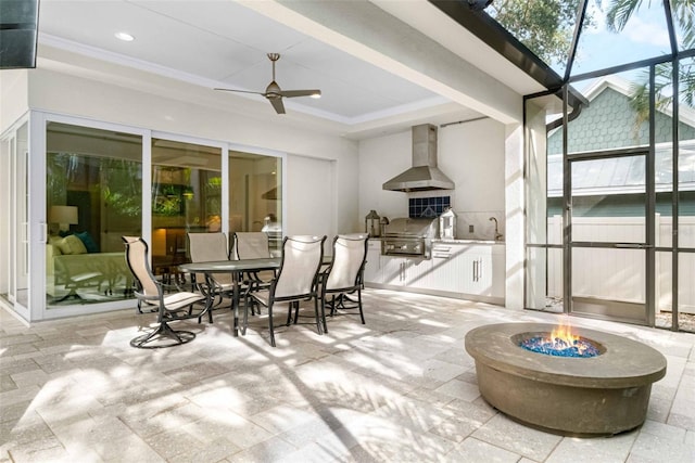 interior space featuring a lanai, ceiling fan, exterior kitchen, grilling area, and an outdoor fire pit