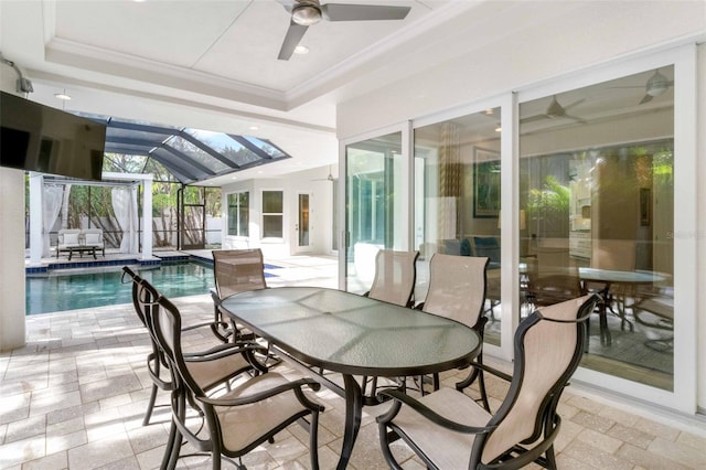 sunroom / solarium with a raised ceiling, ceiling fan, and a swimming pool