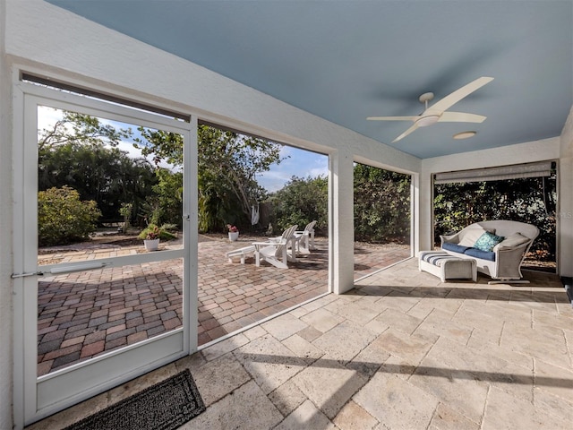 unfurnished sunroom with ceiling fan