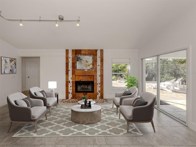 tiled living room featuring lofted ceiling, a tile fireplace, and rail lighting