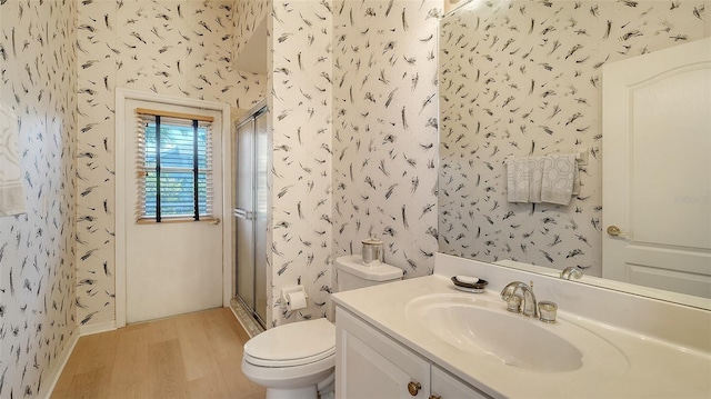 bathroom with walk in shower, toilet, vanity, and hardwood / wood-style flooring