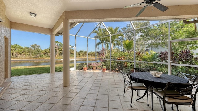 sunroom with ceiling fan, a healthy amount of sunlight, and a water view