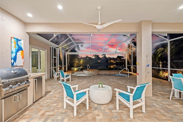 view of patio / terrace featuring glass enclosure, exterior kitchen, and grilling area