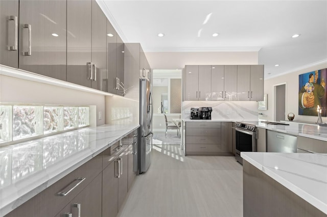 kitchen featuring light stone countertops, appliances with stainless steel finishes, ornamental molding, and gray cabinetry