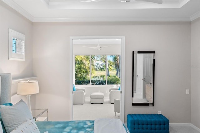 carpeted bedroom featuring ornamental molding, multiple windows, and a tray ceiling