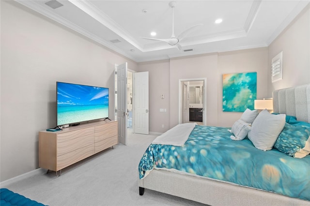 carpeted bedroom with ornamental molding, a raised ceiling, ceiling fan, and ensuite bath