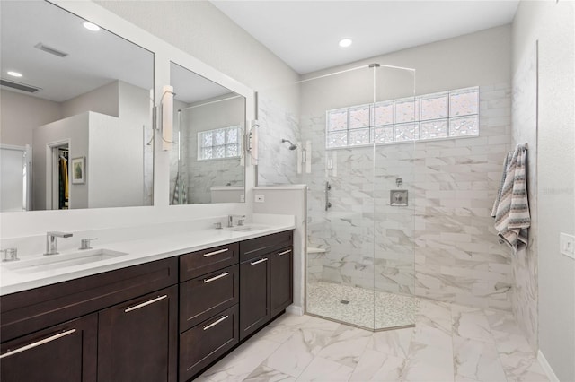 bathroom with tiled shower and vanity