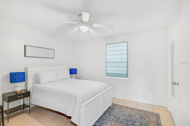 tiled bedroom featuring ceiling fan and a textured ceiling