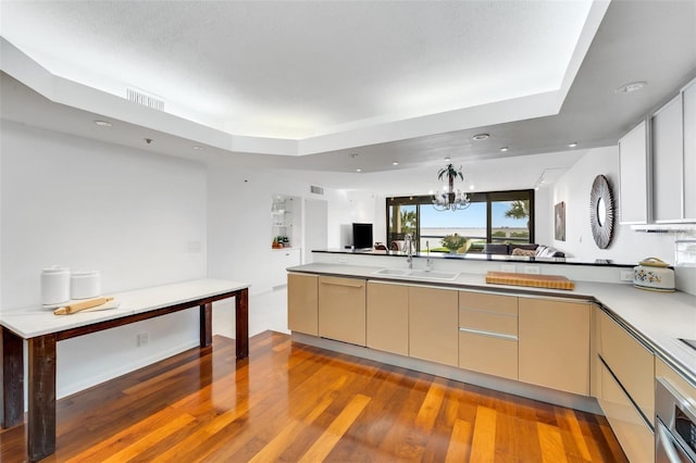 kitchen featuring oven, light hardwood / wood-style flooring, sink, and an inviting chandelier