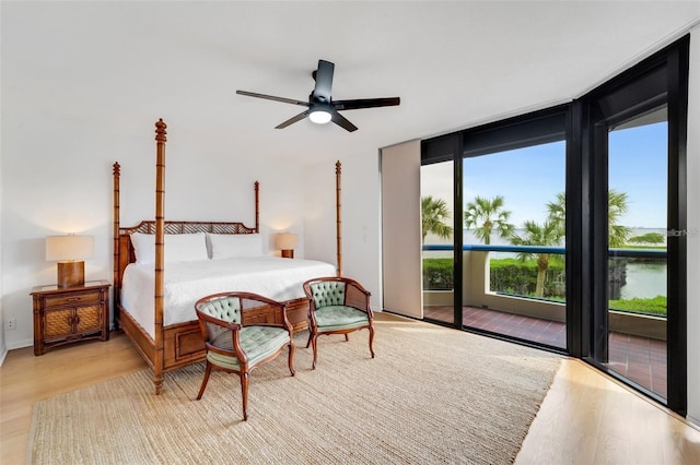 bedroom featuring access to outside, ceiling fan, light hardwood / wood-style flooring, and expansive windows