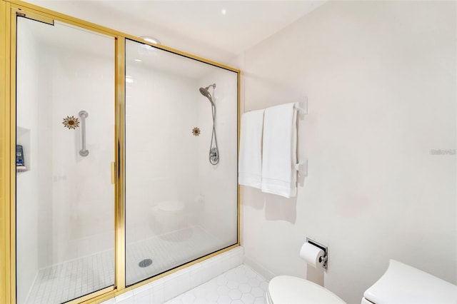 bathroom featuring tile patterned floors, toilet, and a shower with shower door