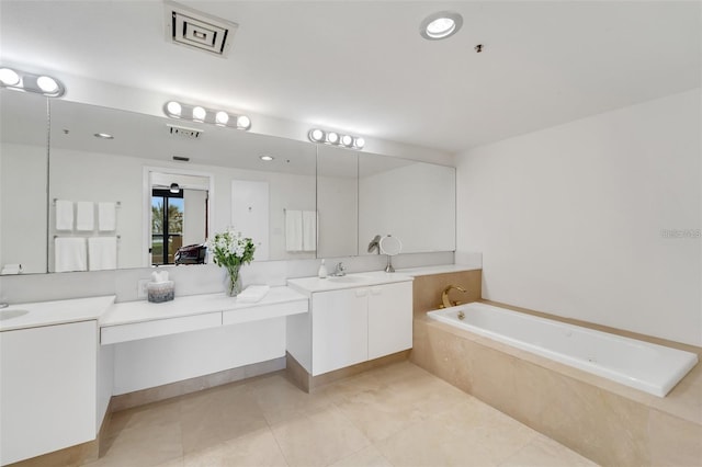 bathroom featuring tile patterned flooring, vanity, and a relaxing tiled tub