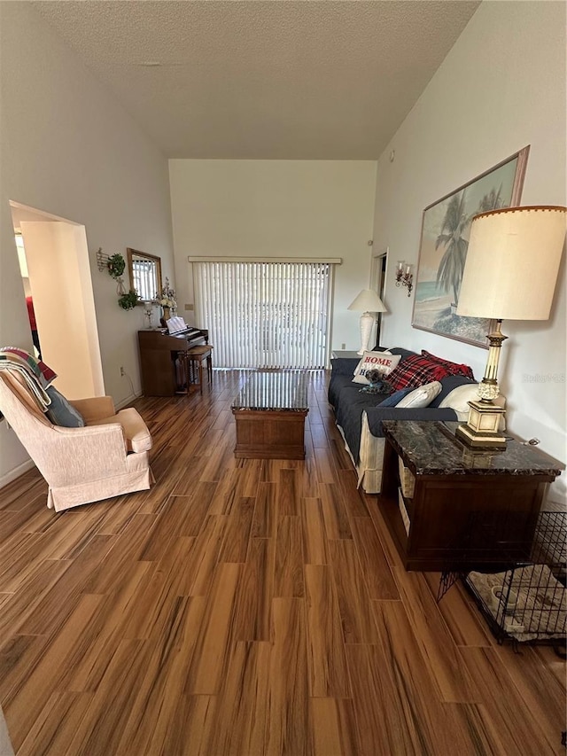 living room with dark hardwood / wood-style flooring and a textured ceiling