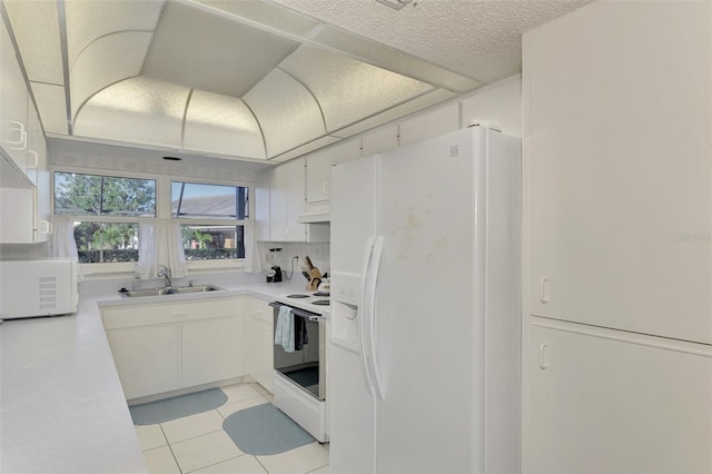 kitchen with sink, white cabinets, decorative backsplash, light tile patterned floors, and white appliances