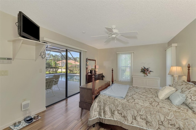 bedroom featuring ceiling fan, access to exterior, and a textured ceiling