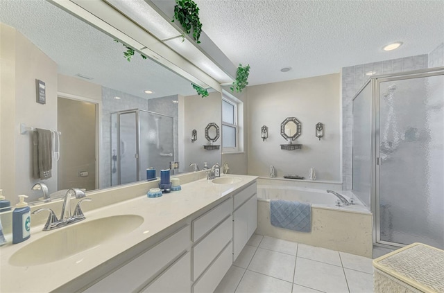 bathroom with vanity, tile patterned floors, plus walk in shower, and a textured ceiling