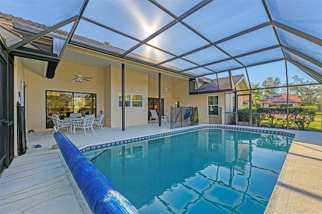 view of pool with ceiling fan, glass enclosure, and a patio area