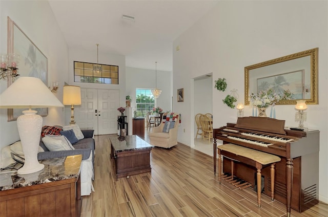 living room with a towering ceiling and an inviting chandelier