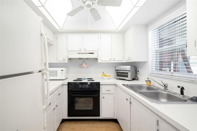 kitchen featuring black appliances, light wood-type flooring, white cabinetry, and sink