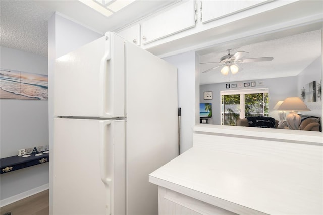 kitchen featuring wood-type flooring, a textured ceiling, white fridge, and ceiling fan