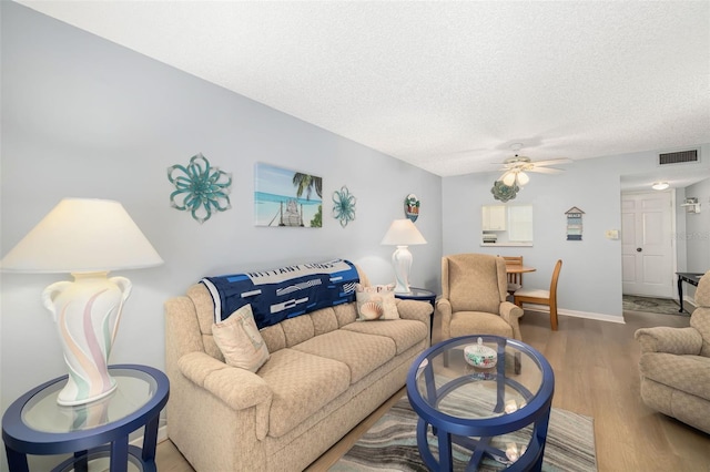 living room featuring a textured ceiling, hardwood / wood-style flooring, and ceiling fan