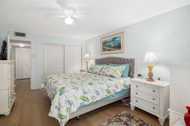 bedroom with hardwood / wood-style floors, a textured ceiling, a closet, and ceiling fan