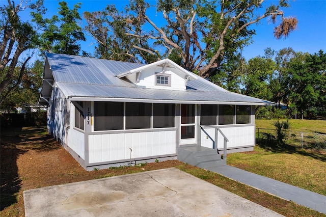 view of front facade featuring a sunroom and a front lawn