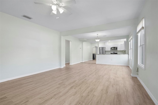 unfurnished living room with a ceiling fan, light wood-type flooring, visible vents, and baseboards