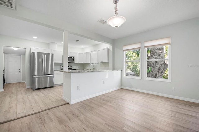 kitchen with stainless steel appliances, white cabinetry, visible vents, and light wood-style floors