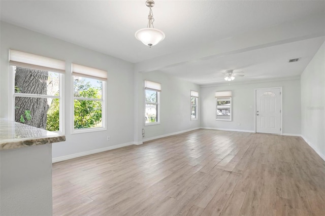 unfurnished living room with light wood-style flooring, visible vents, and baseboards